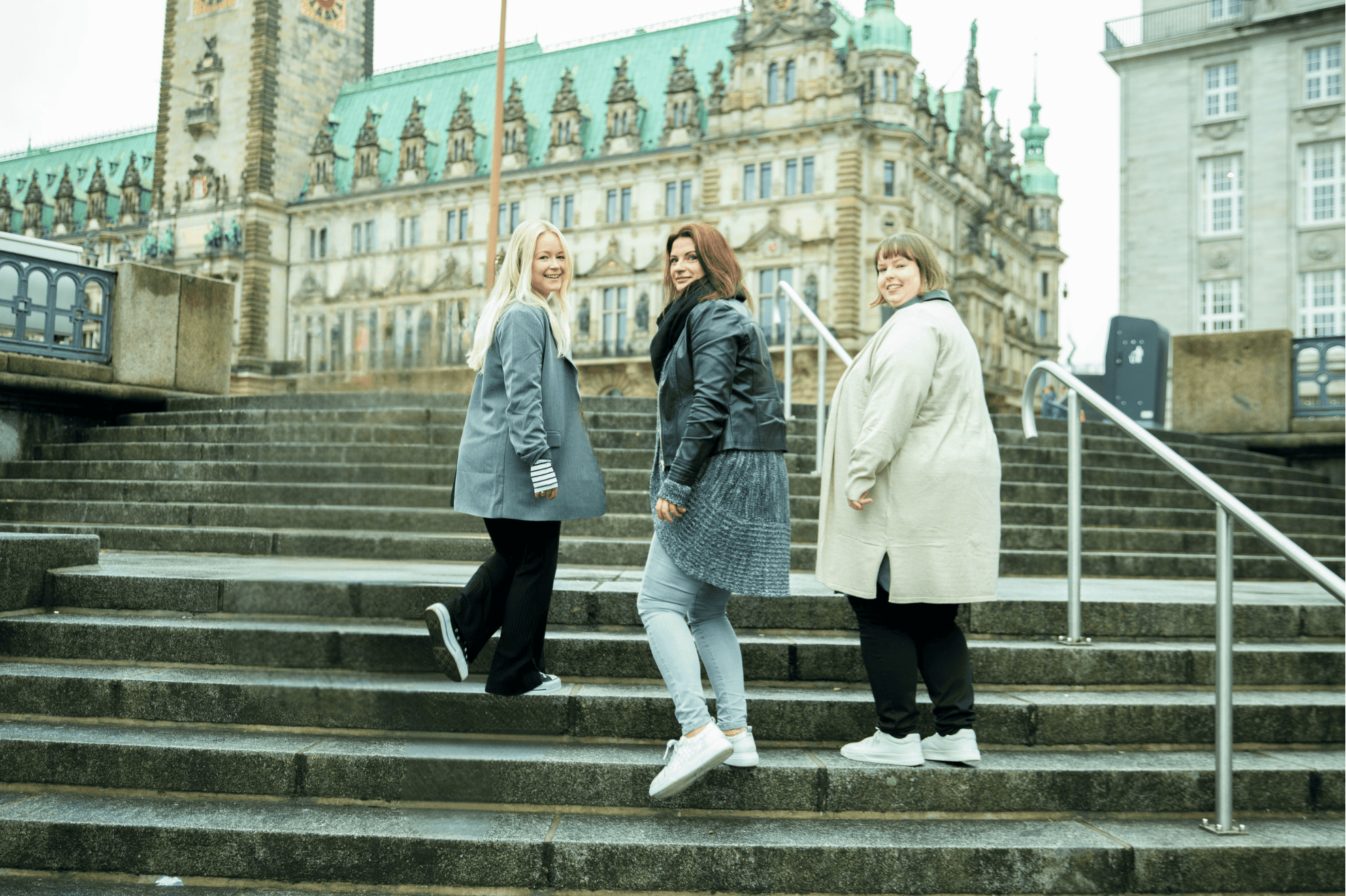 Die drei Inhaberinnen von Maverixxs auf Treppenstufen vor dem Rathaus in Hamburg